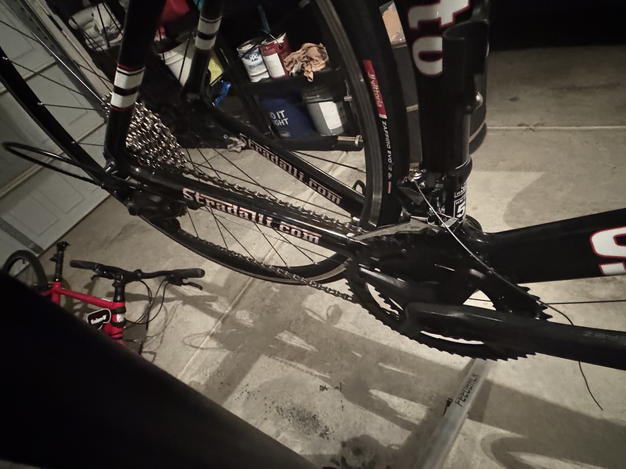 Close-up of the Stradalli's installed crankset, cassette, and chain, with the Vittoria Zaffiro EVO tire visible on the front wheel.